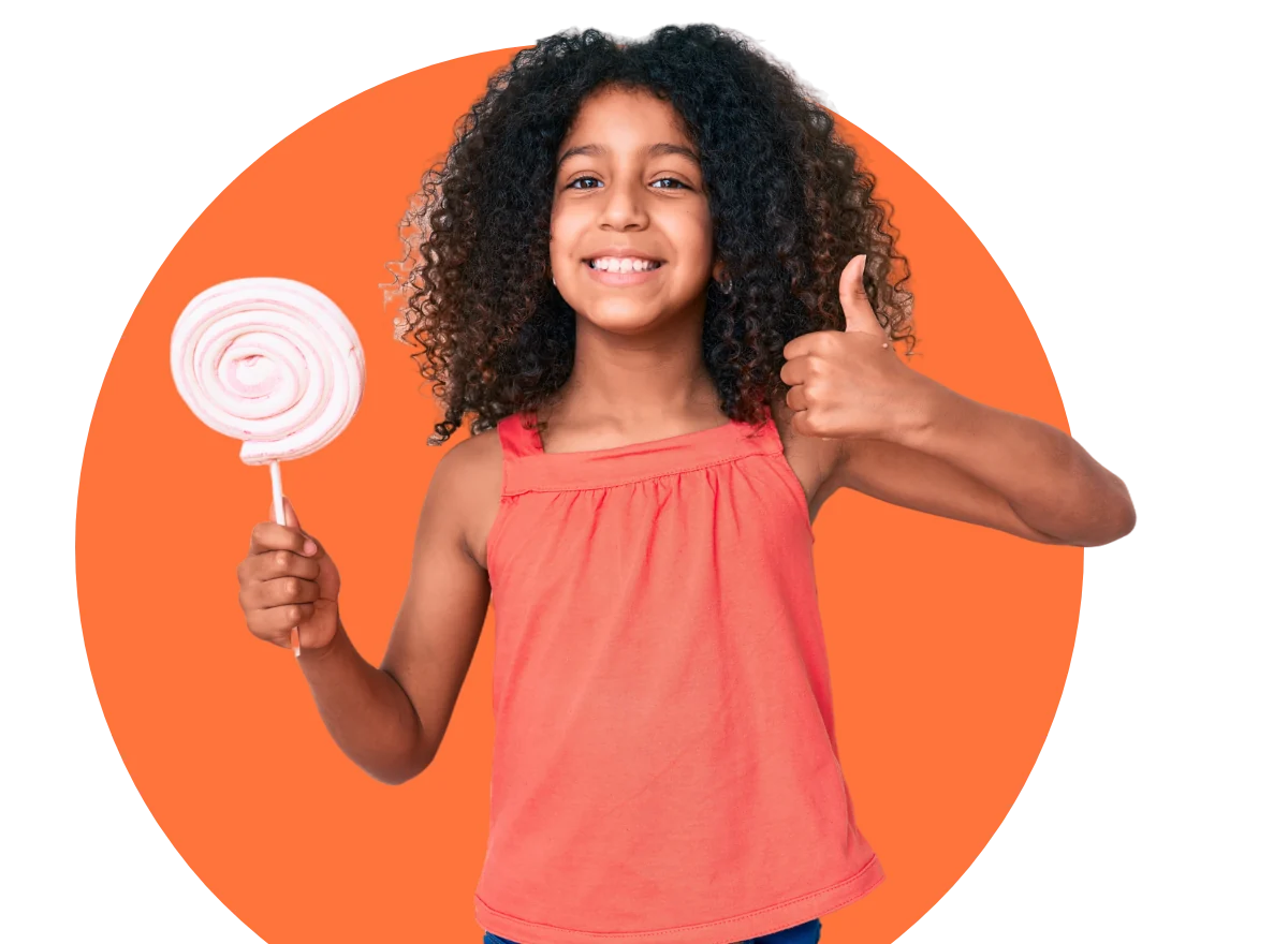 Smiling girl holding a lollipop giving a thumbs up