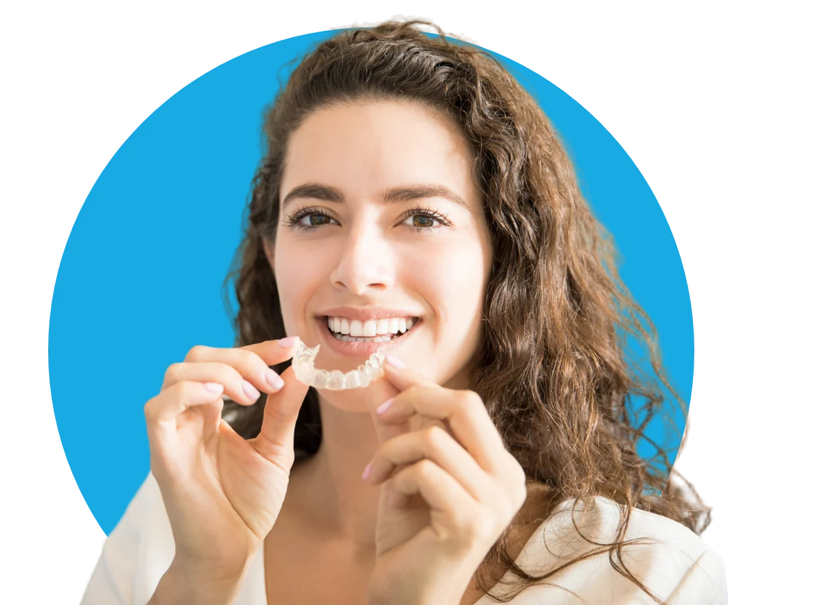Smiling woman holding a clear aligner